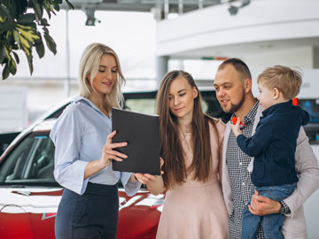 Die junge Familie unterzeichnet das von Autoankauf Kerpen fertiggestellte Angebot